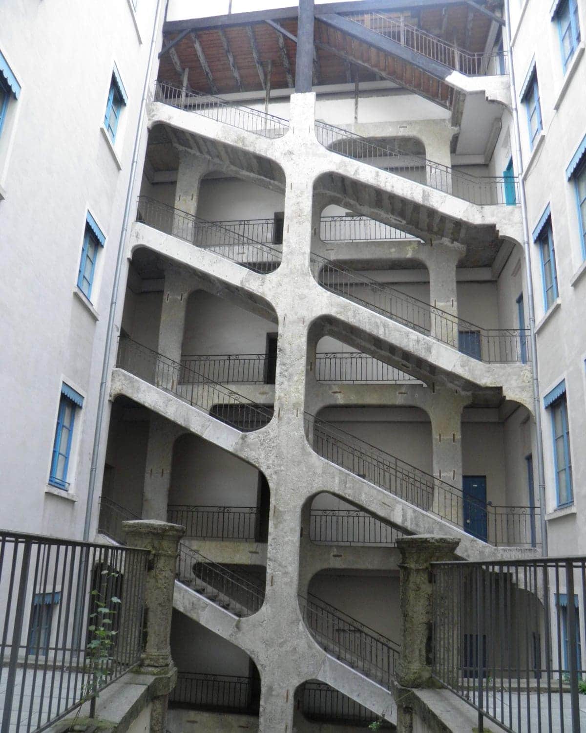 Cour des Voraces à la Croix-Rousse, escalier monumental de pierre grimpant six niveaux à ciel ouvert, Lyon